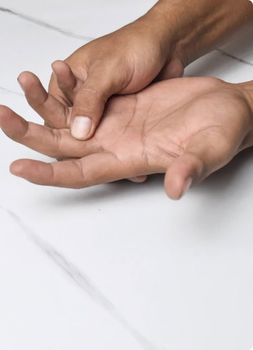 Hand mit Schmerzen, typisch für Gicht, auf weißem Hintergrund.